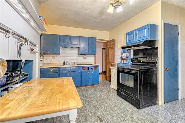 a kitchen with kitchen island a counter top space a refrigerator and a stove