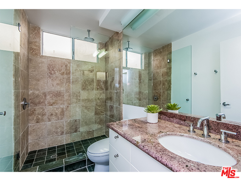 1437 North Tigertail Road Los Angeles, CA 90049 - Photo 18 of 31 a bathroom with a granite countertop sink toilet and shower