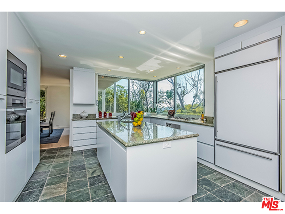 1437 North Tigertail Road Los Angeles, CA 90049 - Photo 8 of 31 a kitchen with stainless steel appliances granite countertop a sink and a large window