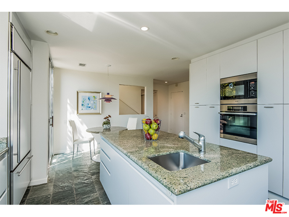 1437 North Tigertail Road Los Angeles, CA 90049 - Photo 10 of 31 a kitchen with granite countertop a sink a stove and cabinets