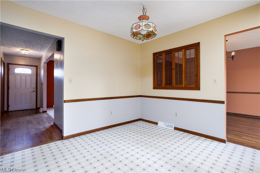 5680 Lance Road Medina, OH 44256 - Photo 17 of 32 Unfurnished room featuring dark hardwood / wood-style floors and a notable chandelier