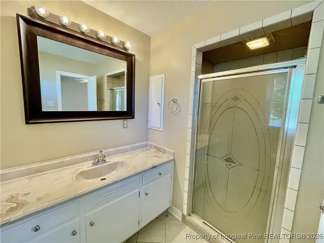 a bathroom with a double vanity sink mirror and shower