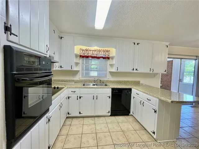 a kitchen with a stove sink and cabinets