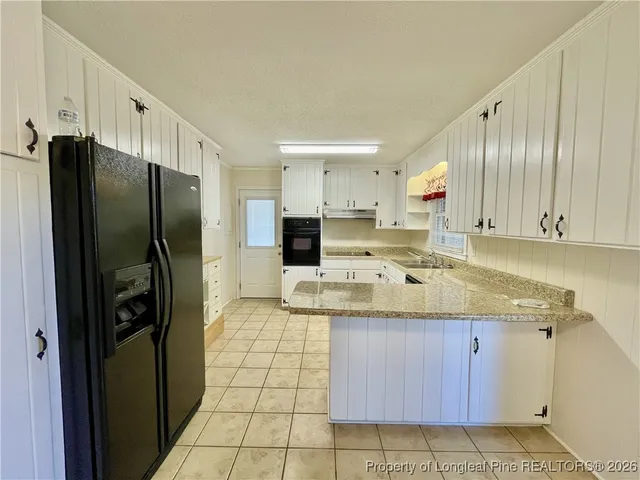 a kitchen with stainless steel appliances granite countertop a refrigerator and a stove