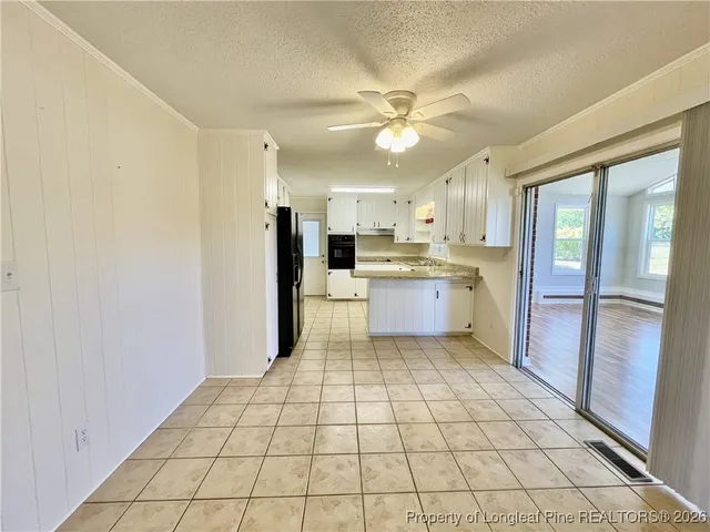 a kitchen with stainless steel appliances a cabinets and window