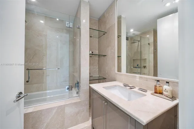 a bathroom with a sink double vanity granite tub shower and a mirror