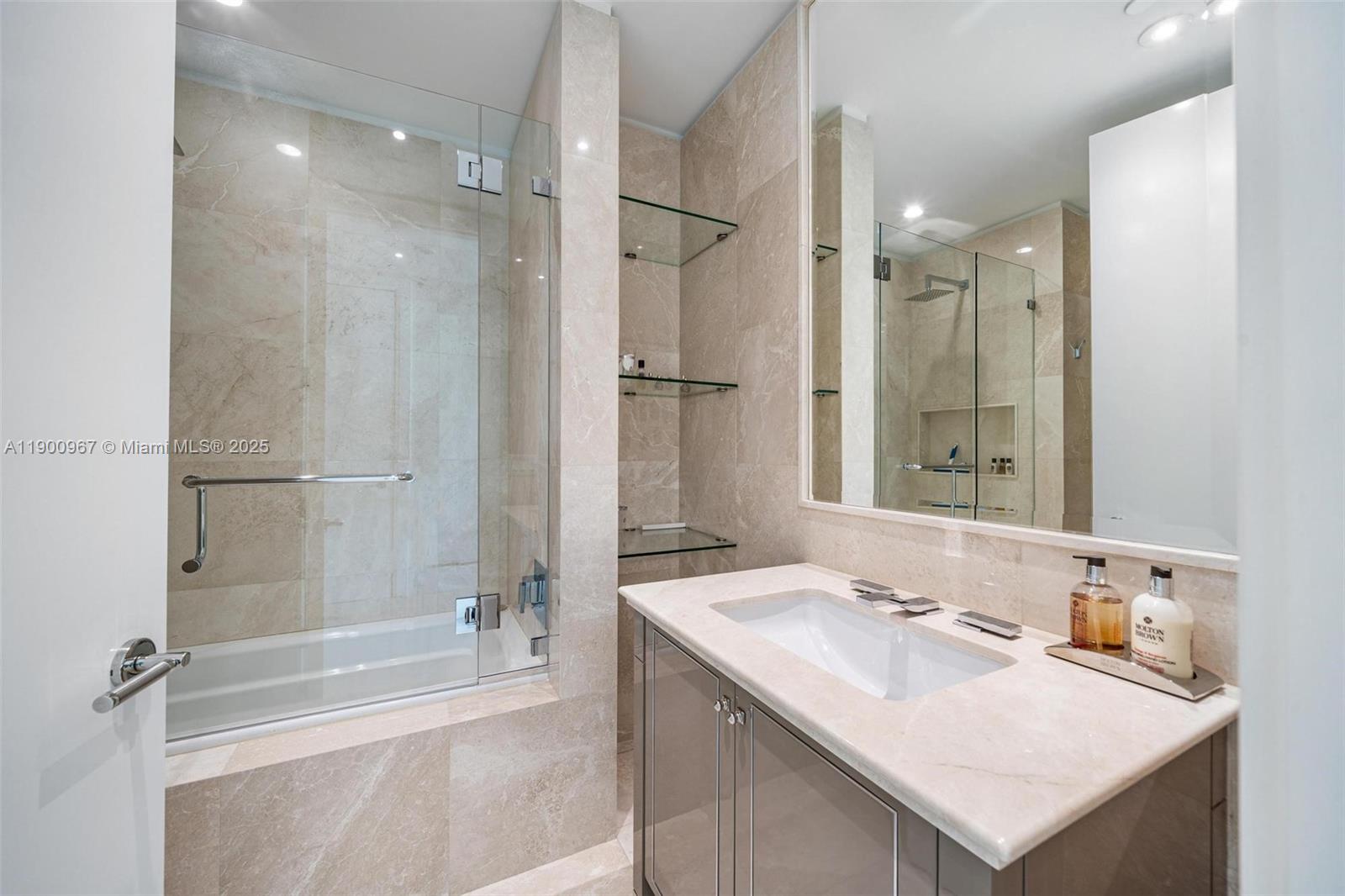 9349 Collins Avenue, Unit 503 Surfside, FL 33154 - Photo 23 of 30 a bathroom with a sink double vanity granite tub shower and a mirror
