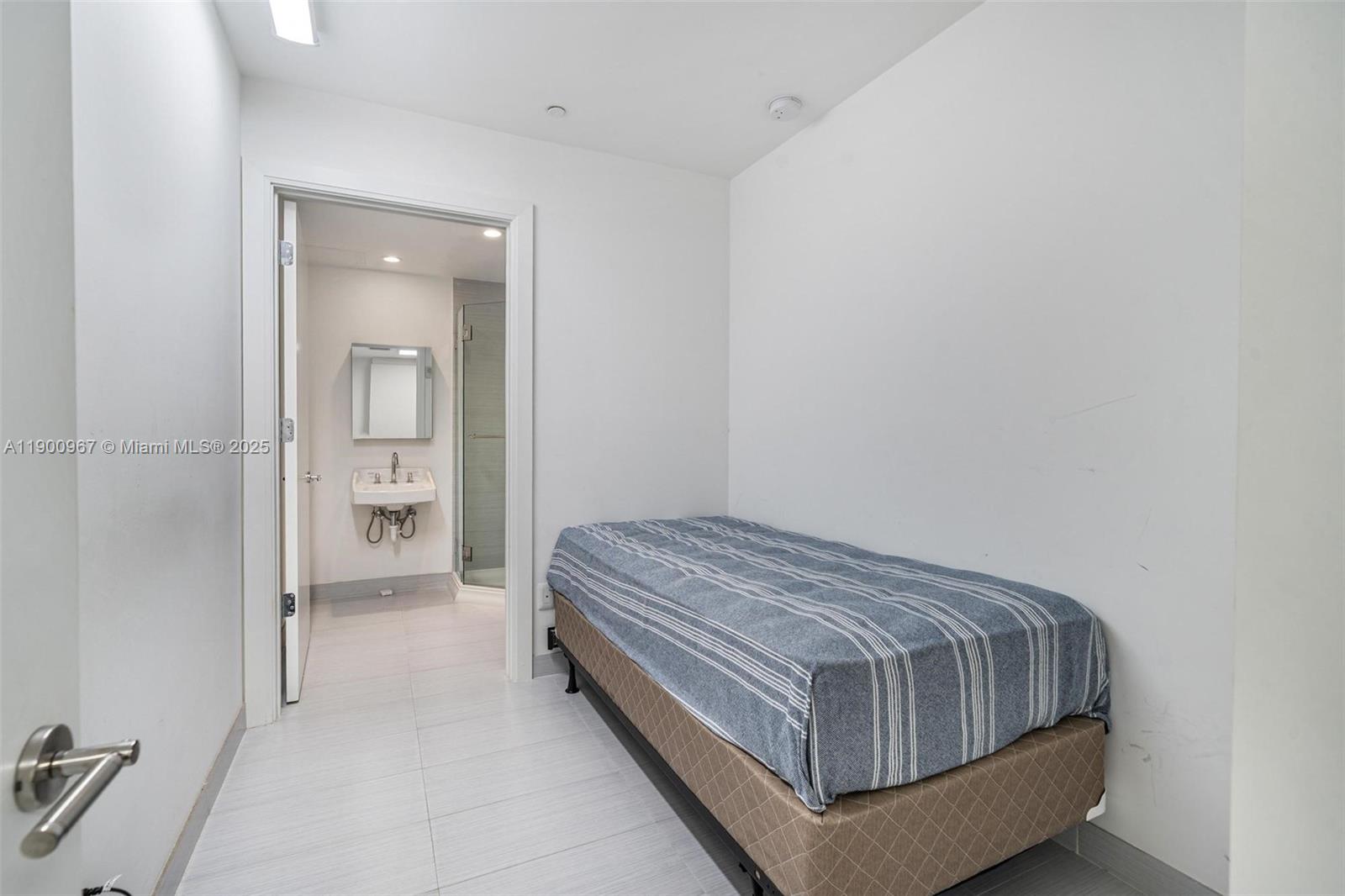 9349 Collins Avenue, Unit 503 Surfside, FL 33154 - Photo 26 of 30 a room with a bed and mirror