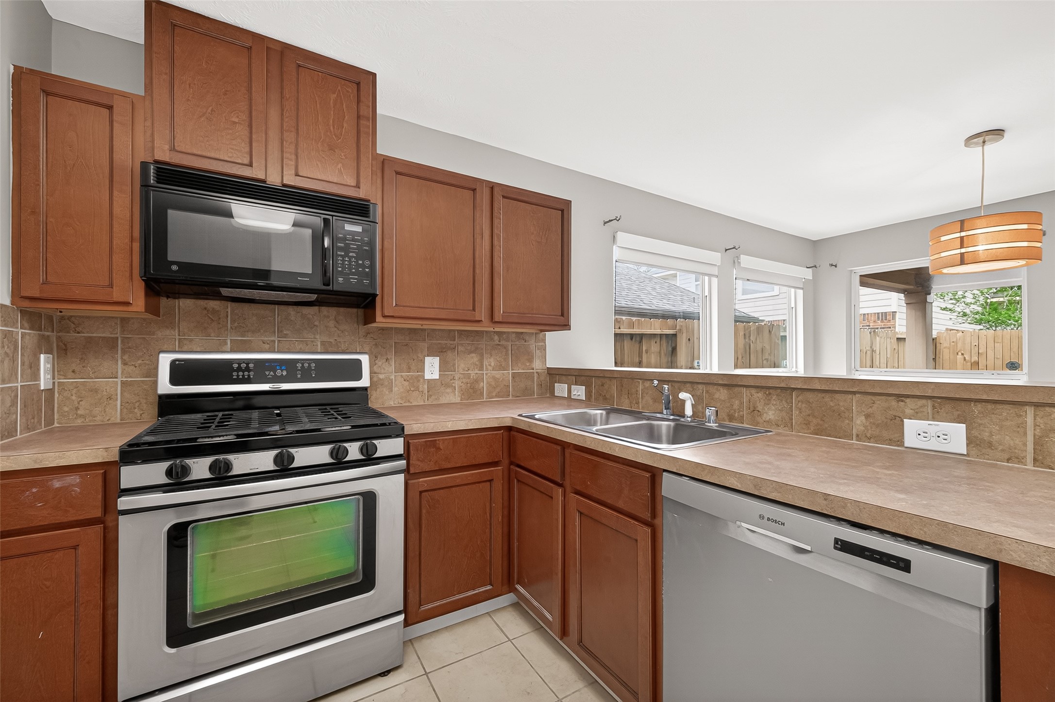2415 Lacyberry Street Houston, TX 77080 - Photo 12 of 50 a kitchen with granite countertop a stove sink and microwave with wooden floor