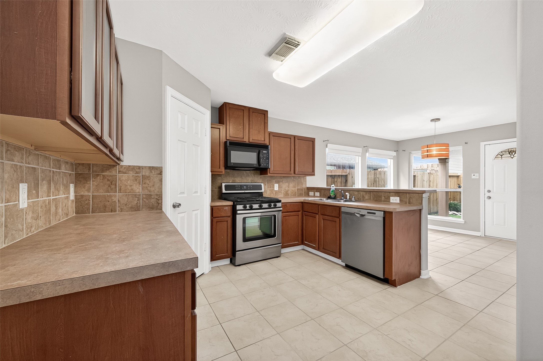 2415 Lacyberry Street Houston, TX 77080 - Photo 10 of 50 a kitchen with stainless steel appliances granite countertop a stove top oven a sink and a refrigerator