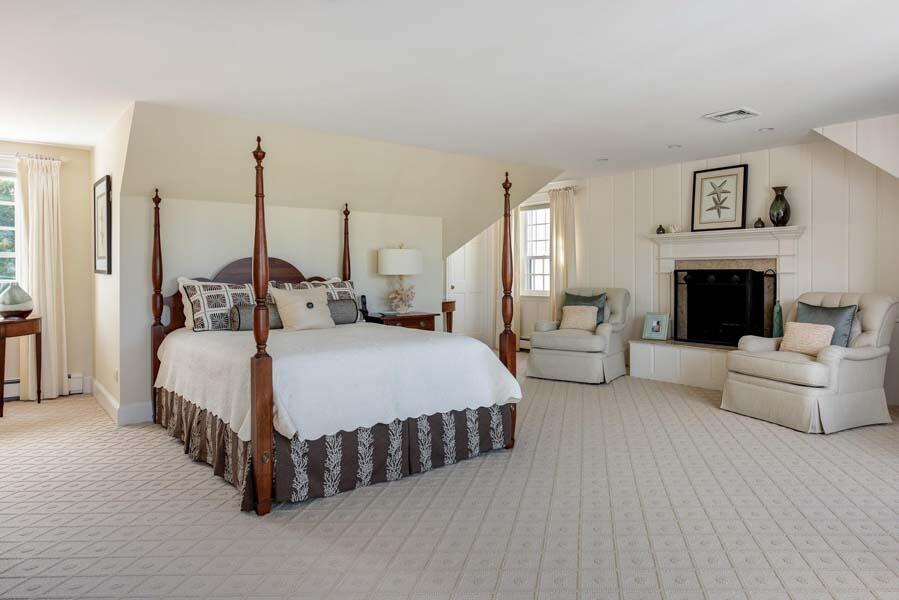 56 Rendezvous Lane Barnstable, MA 02630 - Photo 29 of 38 a spacious bedroom with a bed a couch and a fireplace