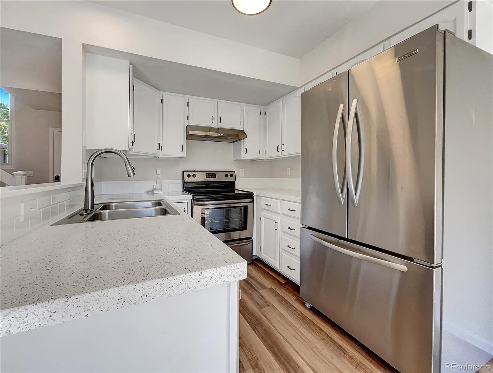 2134 3rd Street Southwest, Unit 2 Loveland, CO 80537 - Photo 13 of 31 a kitchen with stainless steel appliances a refrigerator stove and sink