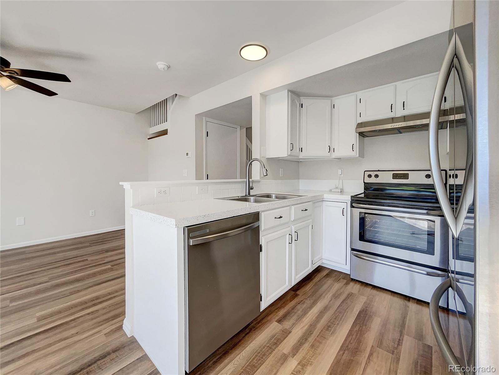 2134 3rd Street Southwest, Unit 2 Loveland, CO 80537 - Photo 14 of 31 a kitchen with a sink stove and cabinets