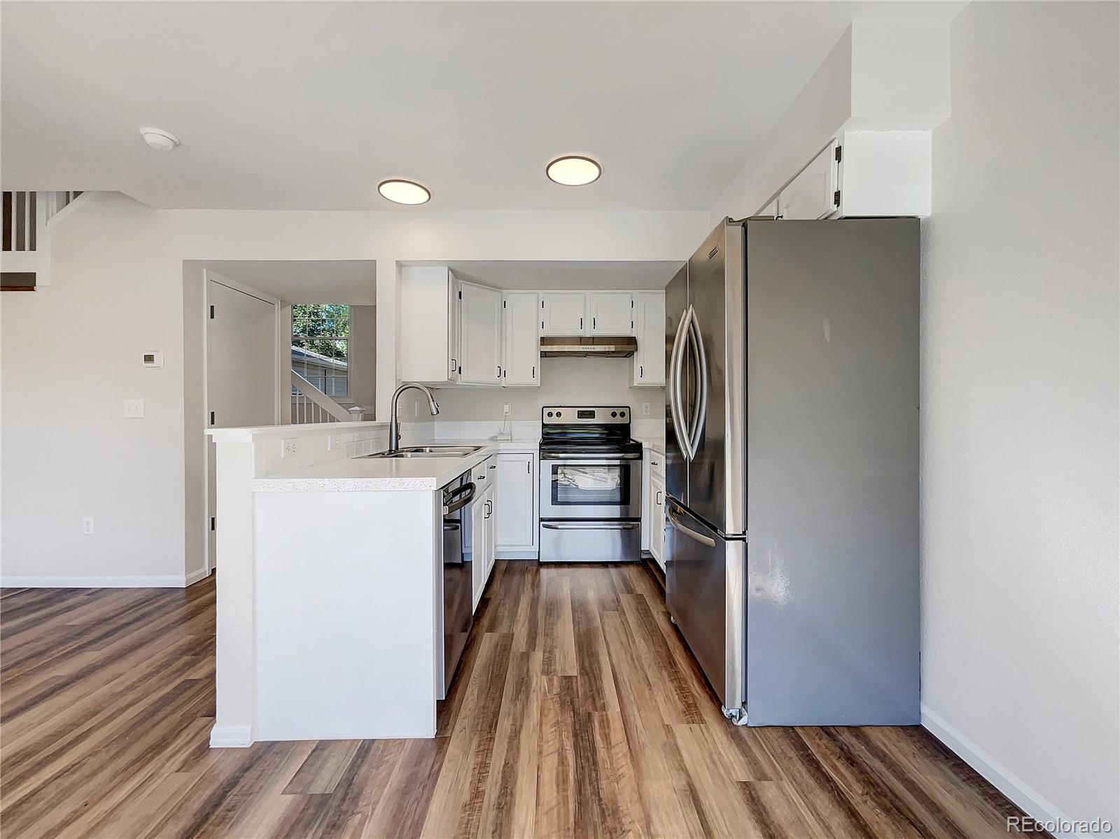 2134 3rd Street Southwest, Unit 2 Loveland, CO 80537 - Photo 2 of 31 a kitchen with a refrigerator sink and cabinets