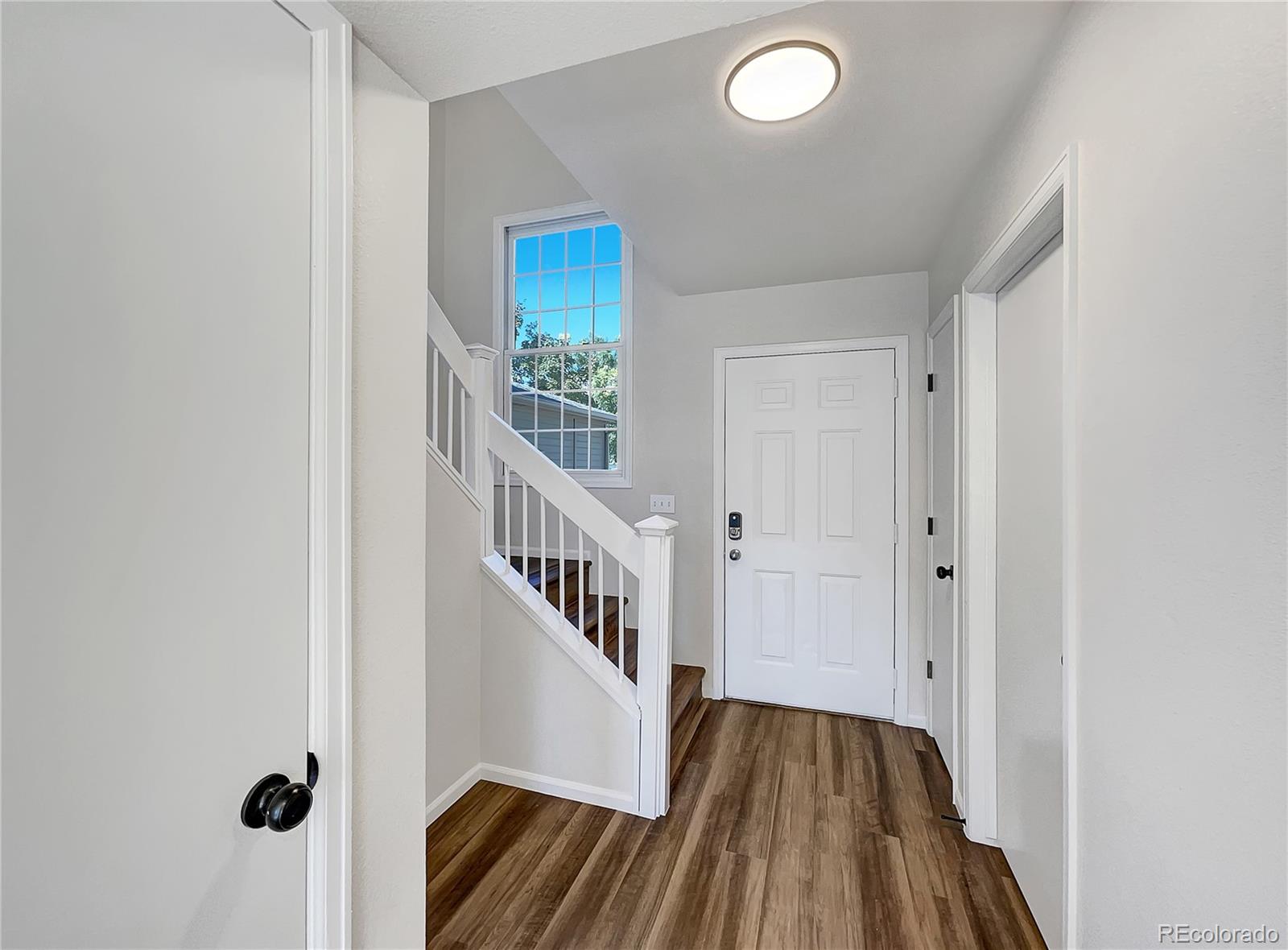 2134 3rd Street Southwest, Unit 2 Loveland, CO 80537 - Photo 9 of 31 a view of a hallway with wooden floor and staircase