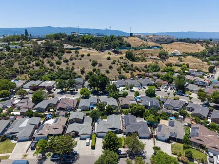 an aerial view of a city with lots of residential buildings and mountain view in back