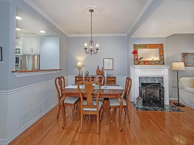 a dining room with furniture a fireplace and wooden floor