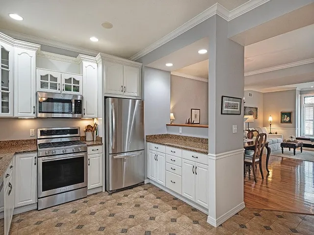 a kitchen with granite countertop a stove oven and refrigerator