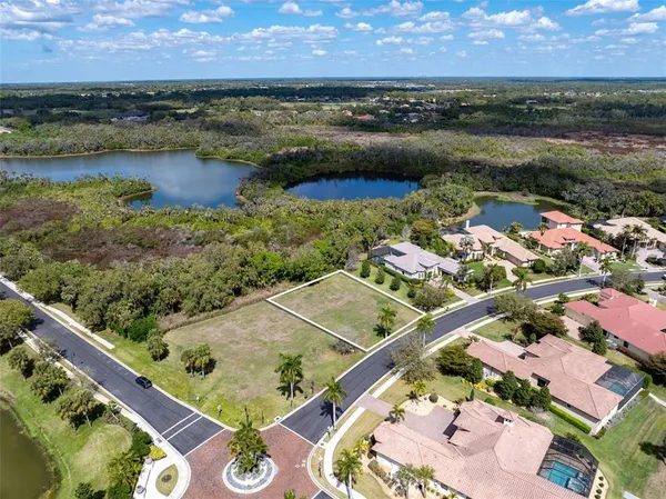 an aerial view of residential houses with outdoor space and lake view