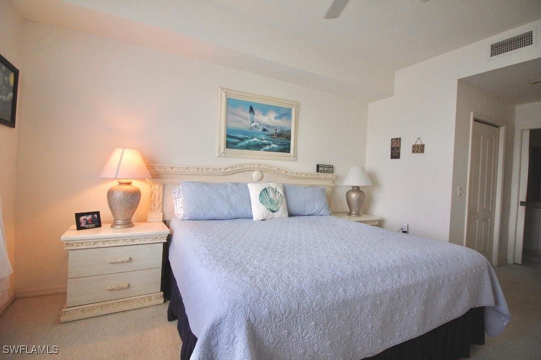 14061 Brant Point Circle, Unit 7304 Fort Myers, FL 33919 - Photo 12 of 49 a bedroom with a bed and a lamp on table
