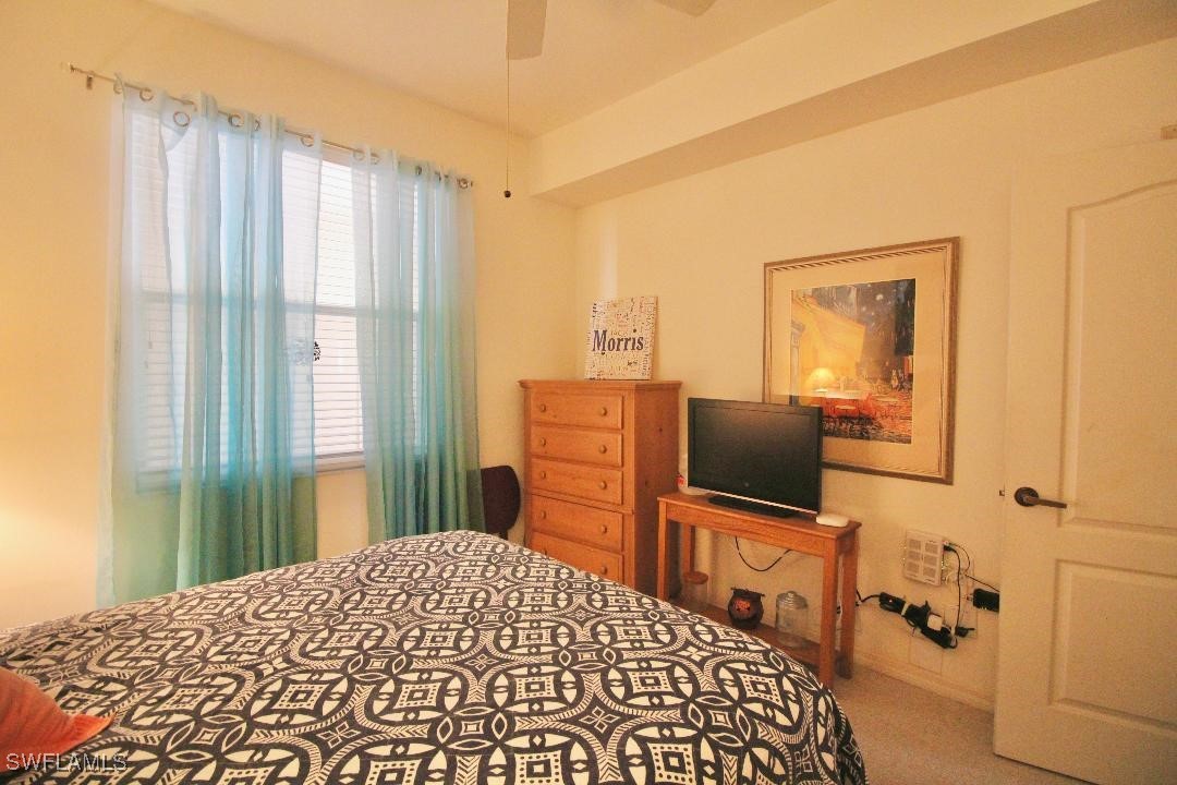 14061 Brant Point Circle, Unit 7304 Fort Myers, FL 33919 - Photo 19 of 49 a bedroom with a bed flat screen tv and a window