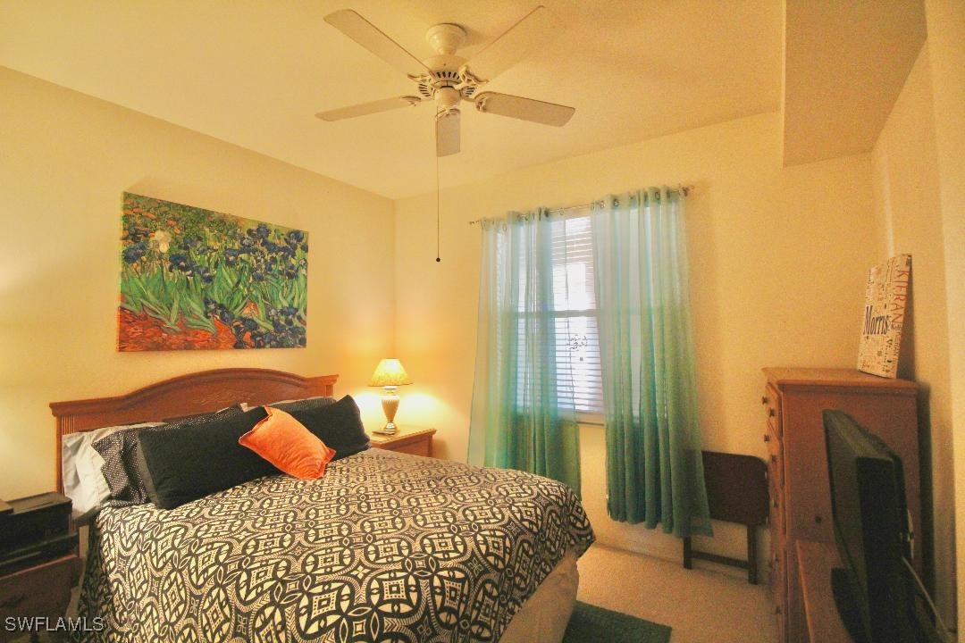 14061 Brant Point Circle, Unit 7304 Fort Myers, FL 33919 - Photo 20 of 49 a bedroom with a bed and a chandelier