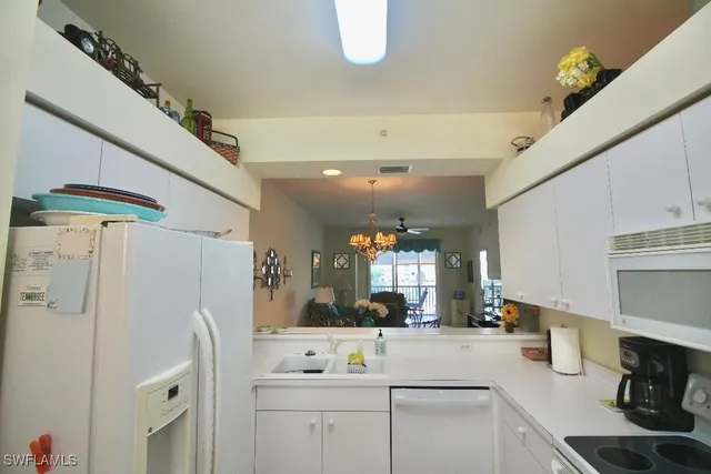 a kitchen with a refrigerator and white cabinets