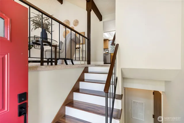 a view of staircase with wooden floor and white walls