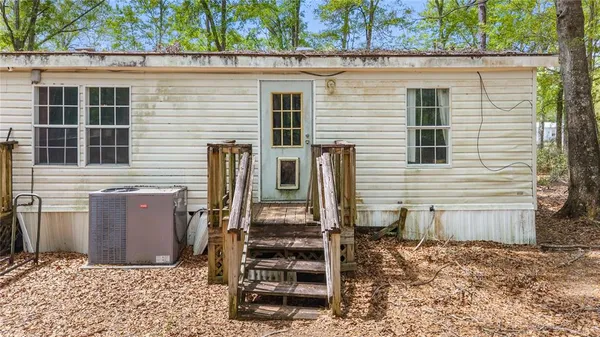a view of a house with backyard and wooden fence