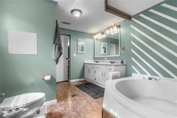 a bathroom with a granite countertop sink mirror vanity and toilet