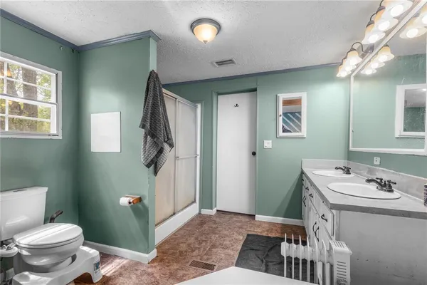 a bathroom with a sink a toilet and shower