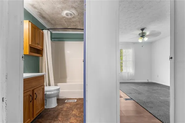 a bathroom with a granite countertop sink a toilet and a window
