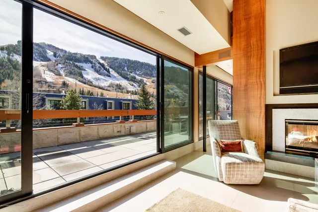a living room with furniture a flat screen tv and a floor to ceiling window