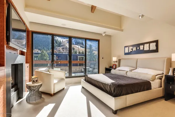 a bedroom with a bed and large windows