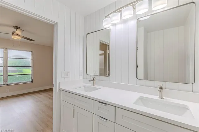 a bathroom with double vanity sinks and a mirror