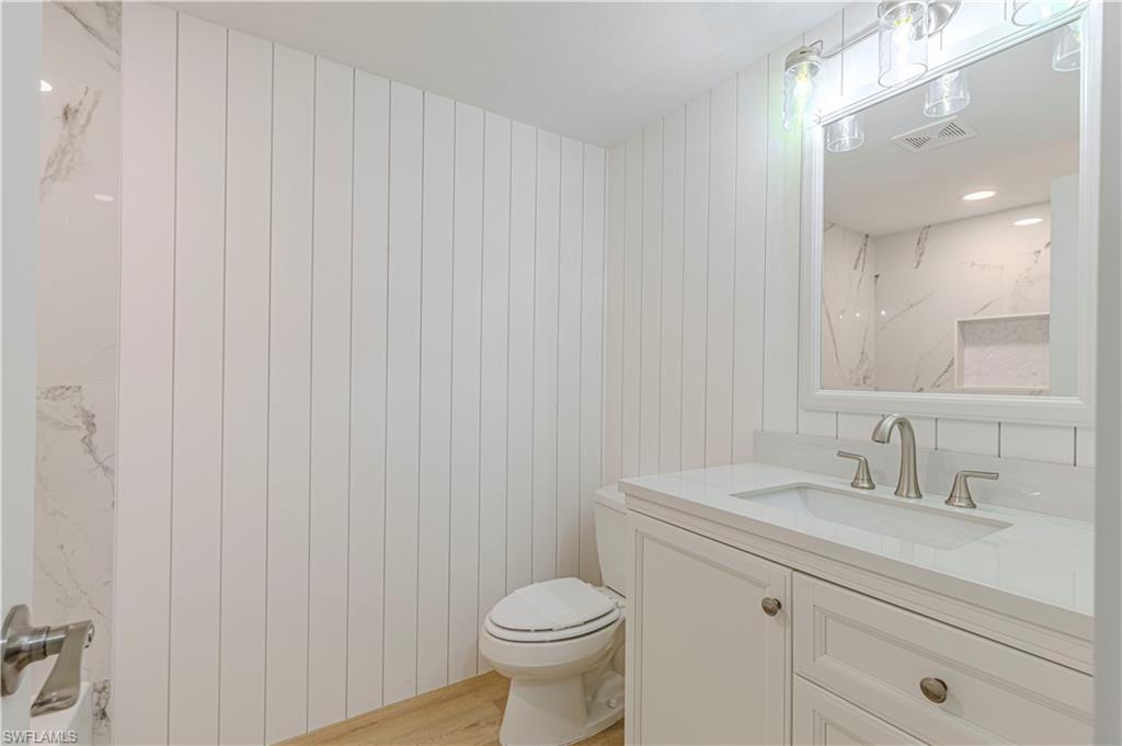 5 Watercolor Way, Unit 5 Naples, FL 34113 - Photo 8 of 13 a bathroom with a sink a toilet and a mirror