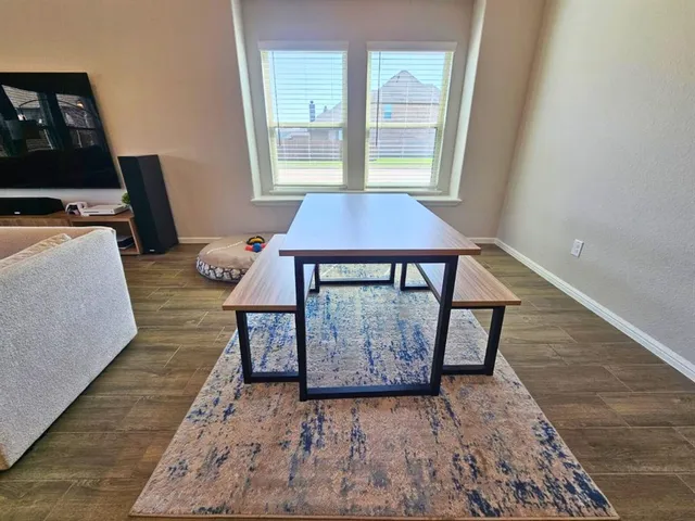 a kitchen with kitchen island granite countertop a stove a sink a refrigerator and white cabinets with wooden floor