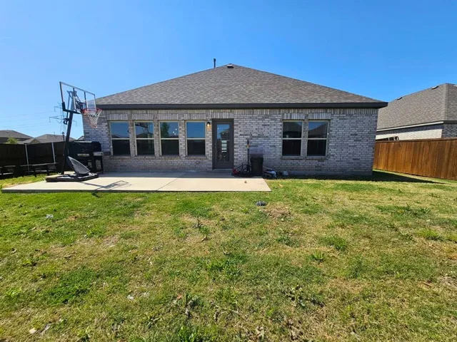 a backyard of a house with a yard and outdoor seating