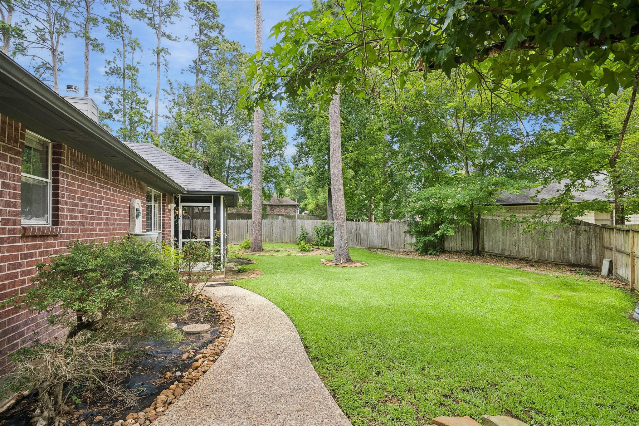 109 Dawns Edge Conroe, TX 77356 - Photo 21 of 24 a view of a backyard with table and chairs and a large tree