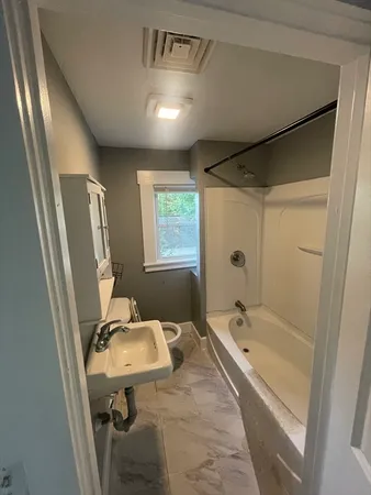 a bathroom with a tub sink and mirror