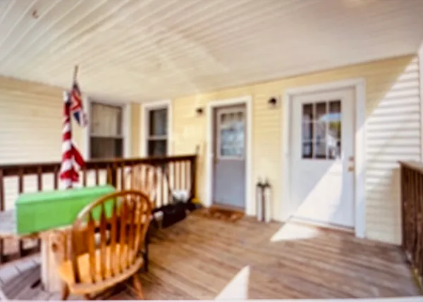 a view of a porch with a table and chairs