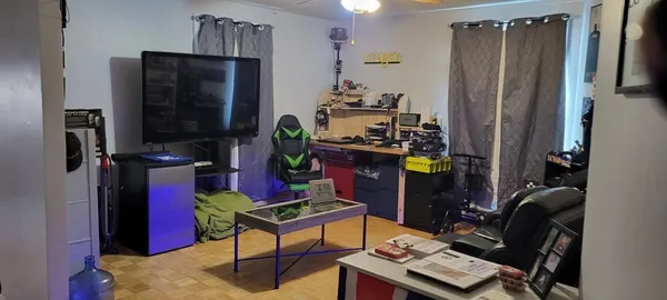 a living room with furniture a flat screen tv and a window