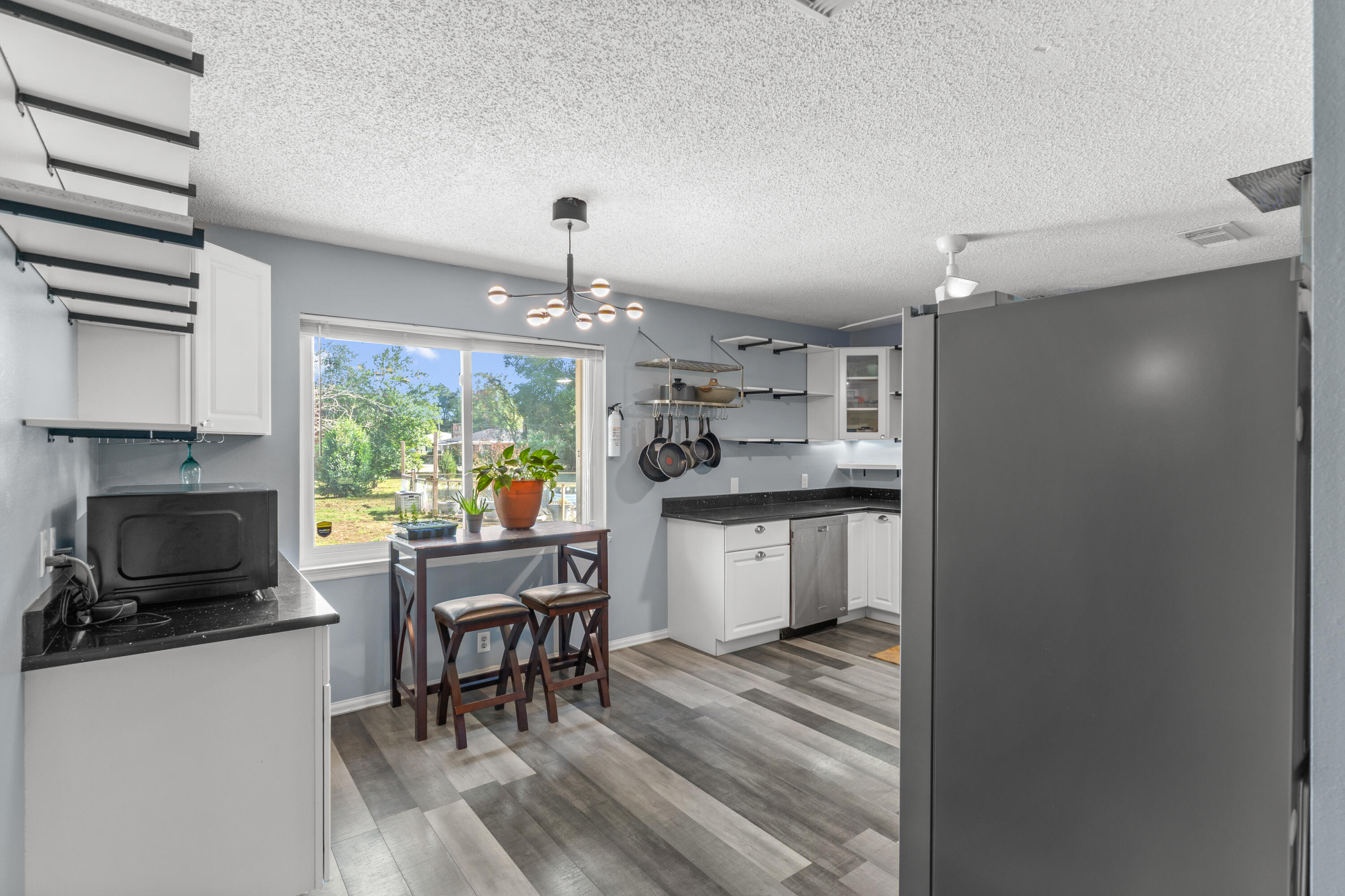 4320 Reinsma Road Milton, FL 32583 - Photo 15 of 41 a kitchen with a table chairs refrigerator and cabinets