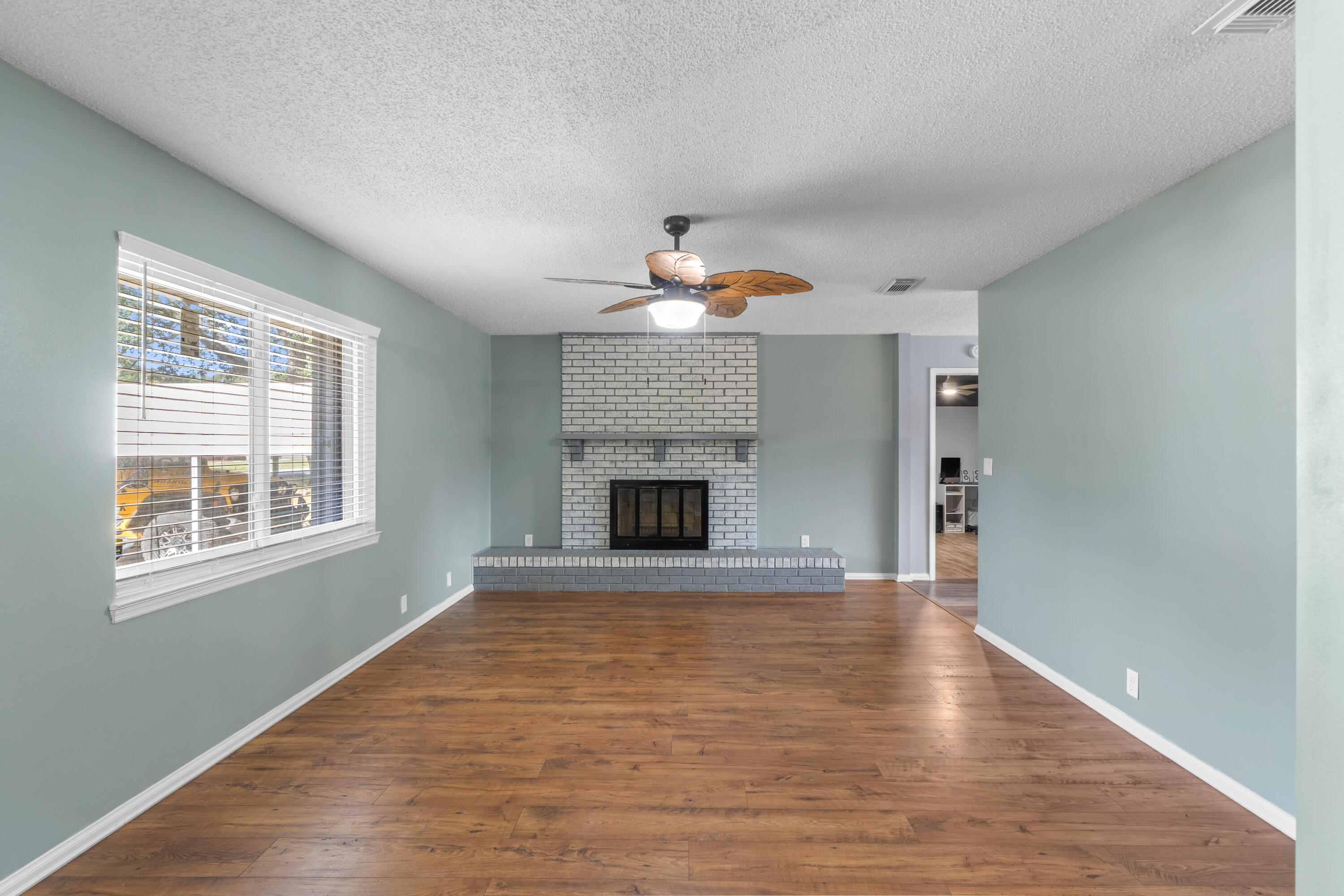 4320 Reinsma Road Milton, FL 32583 - Photo 10 of 41 a living room with a fireplace and wooden floor