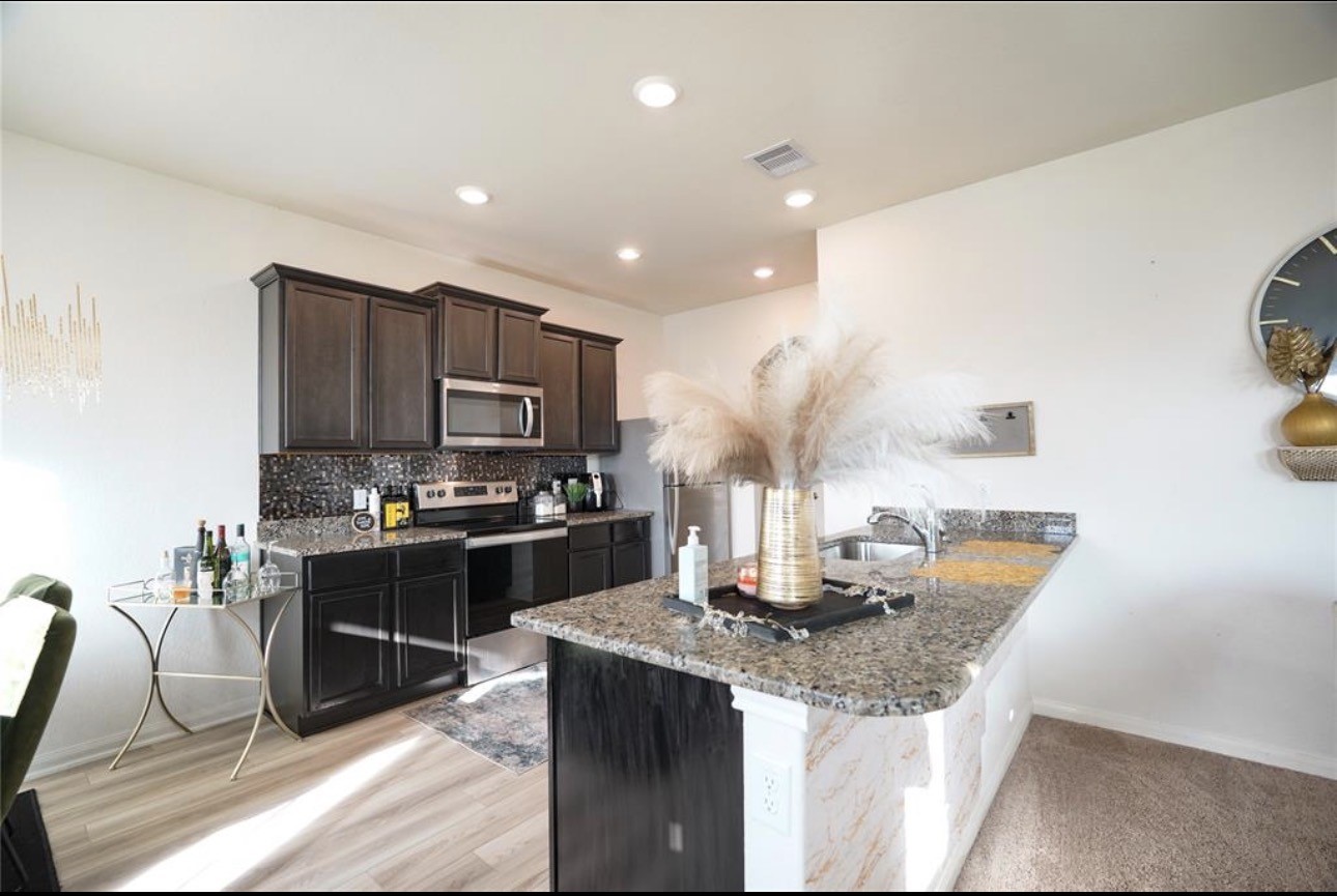 7943 Vacek Meadows Loop Richmond, TX 77469 - Photo 12 of 36 a kitchen with granite countertop a sink and cabinets