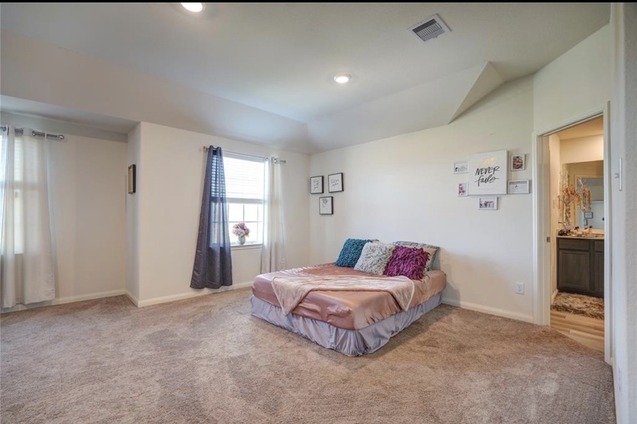 7943 Vacek Meadows Loop Richmond, TX 77469 - Photo 25 of 36 a spacious bedroom with a bed and a window