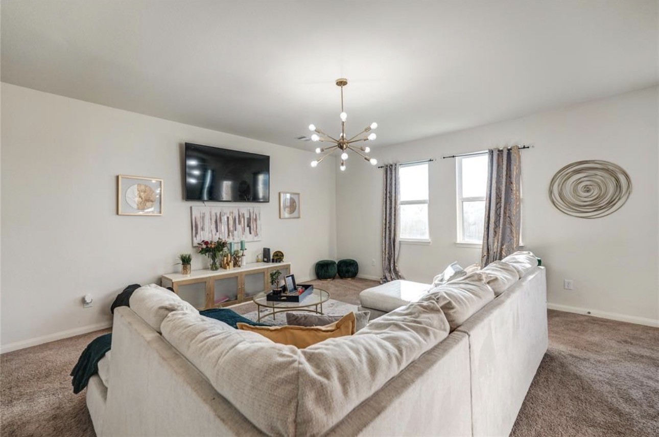 7943 Vacek Meadows Loop Richmond, TX 77469 - Photo 8 of 36 a living room with furniture and a chandelier