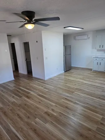 a view of an empty room with wooden floor