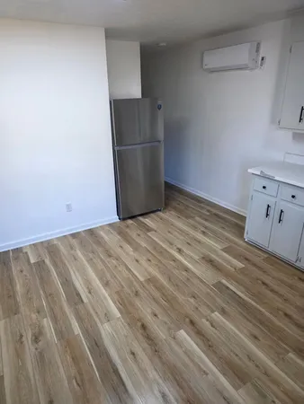 a view of a kitchen with refrigerator and white cabinets
