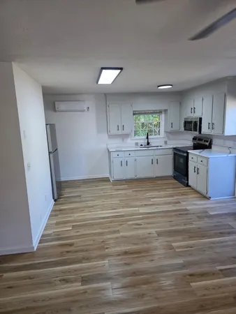 a room with a wooden floor and cabinets